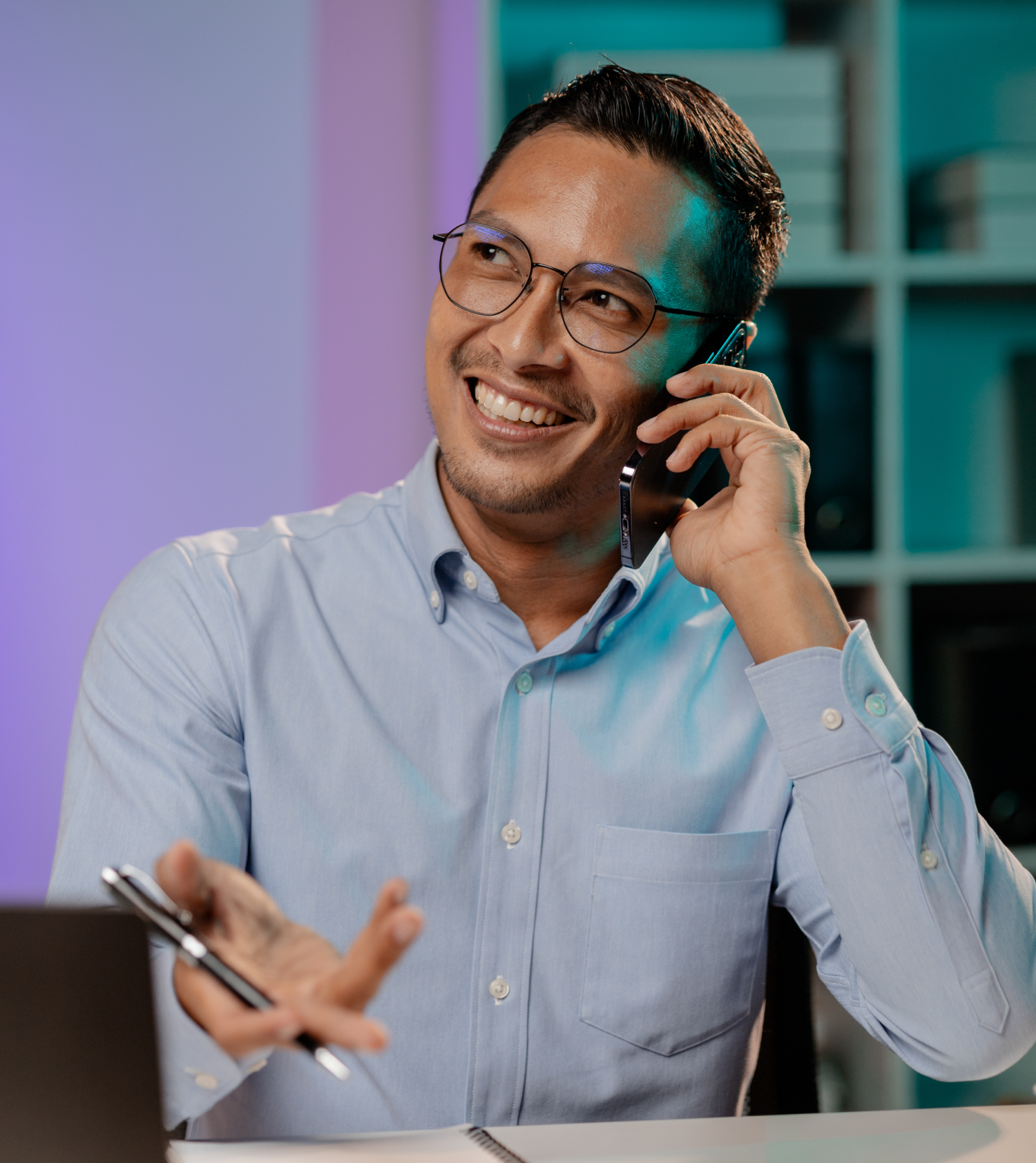 Asian man talking on the phone in the office of a startup company, company employees working overtime, late night work, overtime of a busy and hard working company employee. Overtime concept.